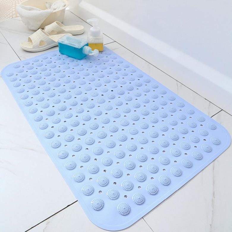 Tapis de bain antidérapant bleu clair avec ventouses, posé près d’une baignoire sur carrelage blanc.