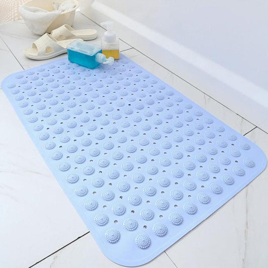 Tapis de bain antidérapant bleu clair avec ventouses, posé près d’une baignoire sur carrelage blanc.